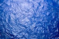 Crumpled blue polyethilene film abstract background with selective focus