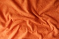 Crumpled reddish orange artificial suede fabric