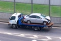 Crumpled car after an accident on a tow truck transported on a highway Royalty Free Stock Photo