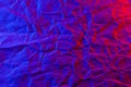 Crumpled craft paper texture in neon red blue light. Solid background