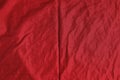 Crumpled dark red fabric as background, top view