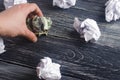 A crumpled dollar on a table next to white paper balls. The process of thinking and finding new business ideas, profitable Royalty Free Stock Photo