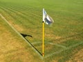 Crumpled flag in corner of footbal playground, lazy wind blowing, sharp shadow