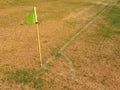 Crumpled flag in corner of footbal playground, lazy wind blowing, sharp shadow