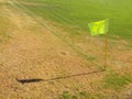 Crumpled flag in corner of footbal playground, lazy wind blowing, sharp shadow