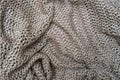 Crumpled folded beige, brown knitted fabric background, woolen knitwear plaid close up