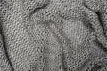 Crumpled folded beige, brown knitted fabric background, woolen knitwear plaid close up