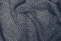 Crumpled folded brown knitted fabric background, woolen knitwear close up