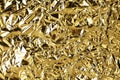 Crumpled golden foil shining texture background, bright shiny gold luxury design, metallic glitter surface Royalty Free Stock Photo