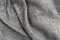 Crumpled gray woolen fabric with folds and wrinkles.