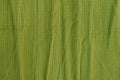 Crumpled green textured cotton fabric. Ribbed texture. Seamless background