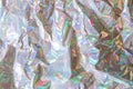 Crumpled holographic wrapping paper with shiny effect. Close up, top view