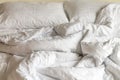 Crumpled messy unmade bed in hotel with pillows