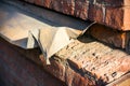 Crumpled metal windowsill of a brick building