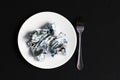 Crumpled money on a plate on a black background, wealth Royalty Free Stock Photo