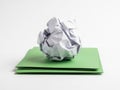 Crumpled paper ball on green paper stack isolated on white background Royalty Free Stock Photo