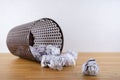 Crumpled paper balls all around a black recycle bin Royalty Free Stock Photo