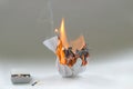 Crumpled paper burning in fire and matchbox.