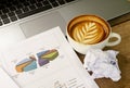 Crumpled paper with coffee cups and labtop computer woth chart for business finance concept backgrounds Royalty Free Stock Photo