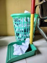 The crumpled paper in a garbage green basket