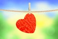 Crumpled paper heart hanging on rope over nature background Royalty Free Stock Photo