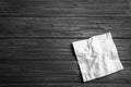 Crumpled paper napkin and space for text on wooden background Royalty Free Stock Photo