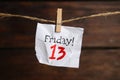 Crumpled paper note with phrase Friday! 13 hanging on twine. Bad luck superstition
