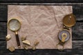 Crumpled paper page, compass, gold and magnifying glass. Royalty Free Stock Photo