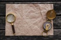 Crumpled paper page, compass and magnifying glass. Royalty Free Stock Photo