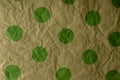 crumpled paper. sheet of dull yellow paper with green circles. detailed high resolution texture. abstract background for wallpaper Royalty Free Stock Photo