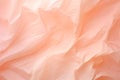 Crumpled peach fuzz color paper texture background. The wrinkled design paper, fabric folds, crumpled fabric. Close up