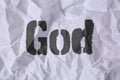 Crumpled paper with word God as background, top view