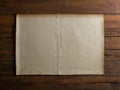 crumpled parchment old worn paper page with yellowing edges on wooden table background texture with copyspace Royalty Free Stock Photo