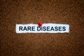 A crumpled piece of paper with the words Rare diseases on it pinned to a corkboard