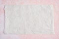 Crumpled piece of white parchment or baking paper on rose and white texture pattern background