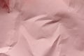 Crumpled pink paper texture background. Packaging process. Gift shop. Decorative wrapping.