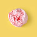Crumpled pink table-napkin on yellow background.