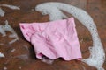 Crumpled Pink Viscose Dish cloth on kitchen table with foam