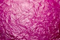 Crumpled plastic pink polyethilene film abstract background with selective focus