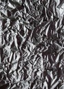 Crumpled silver aluminum foil closeup background texture. Abstract metallic paper holographic pattern. Vertical top view Royalty Free Stock Photo