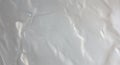A crumpled surface with a glossy finish, possibly plastic or foil. The light reflects Royalty Free Stock Photo