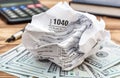 Crumpled tax form with money, calculator and notepad on the table. Close up Royalty Free Stock Photo