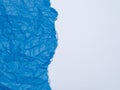 Crumpled and torn blue paper on a white background Royalty Free Stock Photo