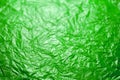 Crumpled ufo green polyethilene film abstract background with selective focus