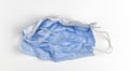 Crumpled used disposable medical face mask on white background Royalty Free Stock Photo