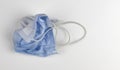 Crumpled used disposable medical face mask on white background Royalty Free Stock Photo