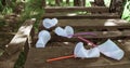 Crumpled white plastic glasses and plastic straws on a wooden table in the forest