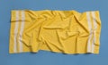 Crumpled yellow beach towel on blue background, top view Royalty Free Stock Photo