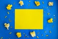 Crumpled yellow papers and office supplies in yellow on blue background with paper for your text, frame copy space Royalty Free Stock Photo