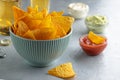 Crunchy nachos in blue bowl on table with dip sauces and beer. Royalty Free Stock Photo